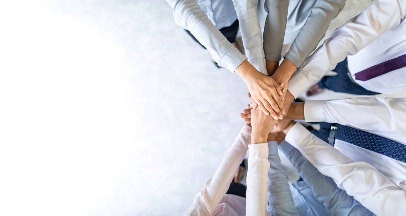 close up top view of young business people putting their hands together stack of hands unity and teamwork concept