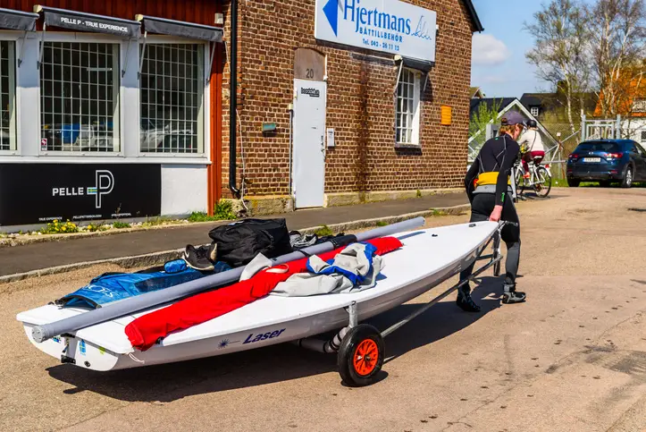 A man towing his sailboat with his bike.