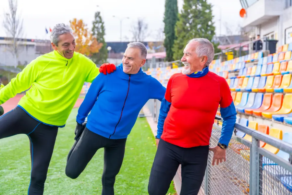 Old friends having fun stretching and working out in a running track.