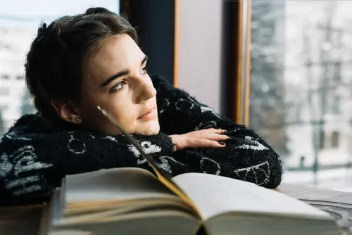 A woman being inspired to do more with her life by reading a memoir.